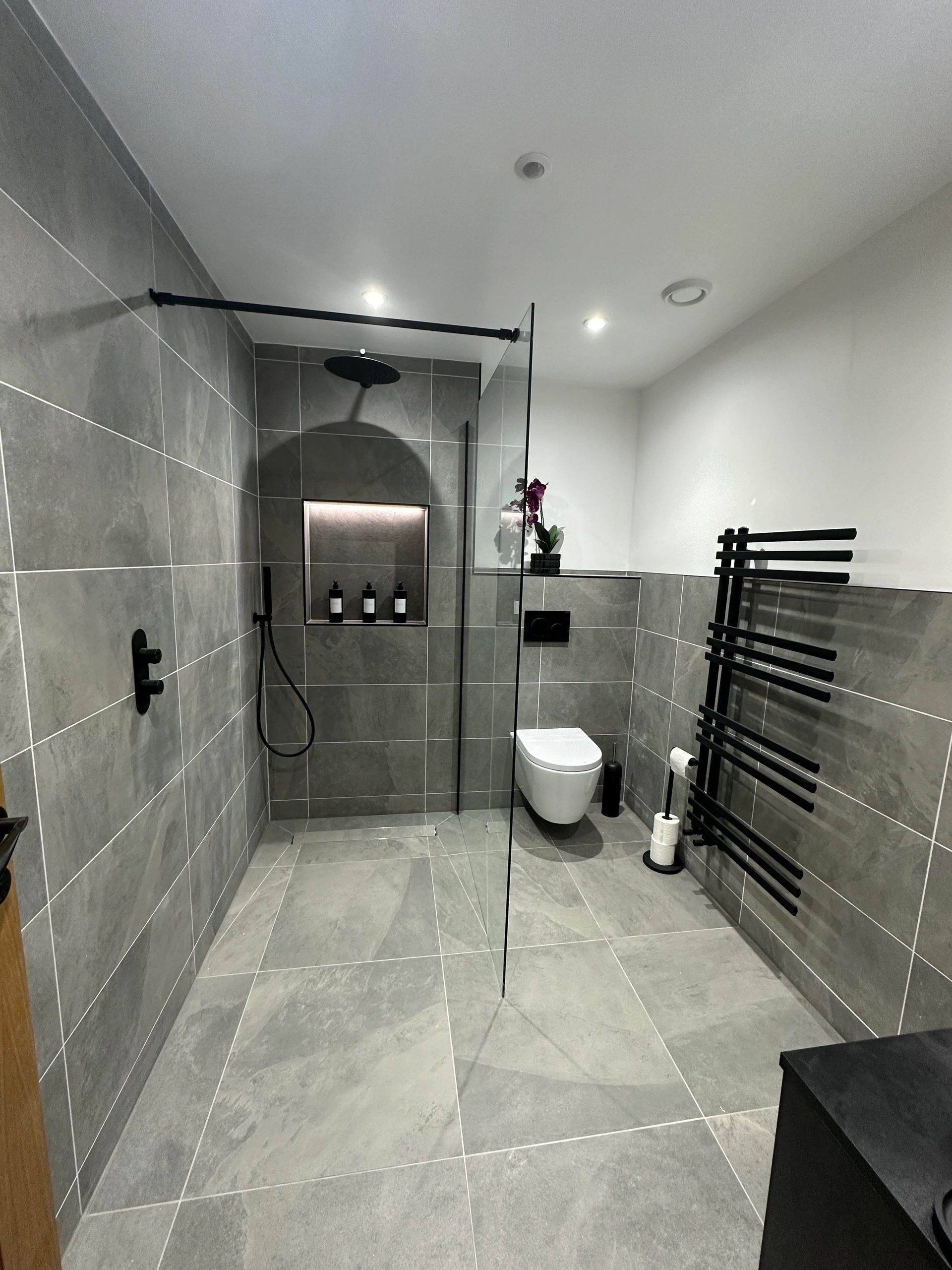 Interior finish detail — tiled bathroom with black fixtures